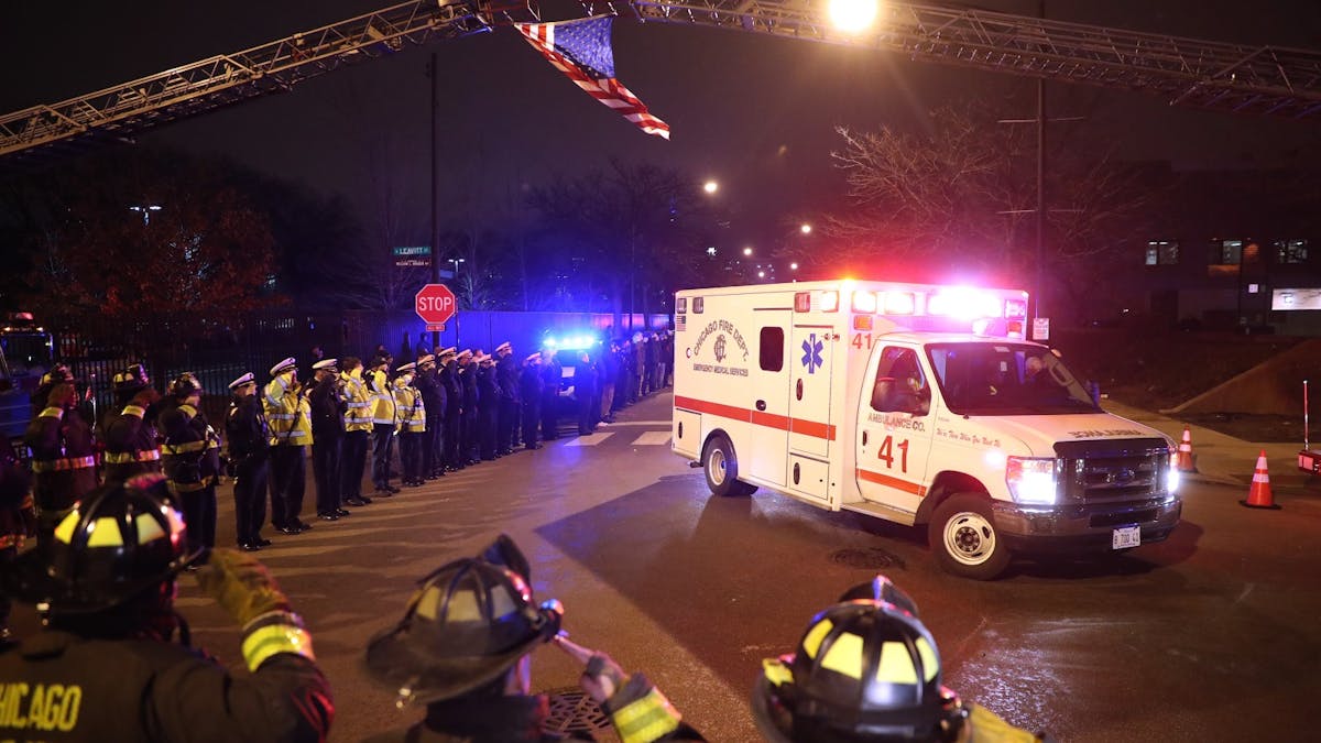 Chicago firefighters and police salute the ambulance carrying the body of Officer Samuel Jimenez outside of the Medical Examiners office at Leavitt and West Harrison streets in Chicago on Nov. 19, 2018. Jimenez was killed at Mercy Hospital today.