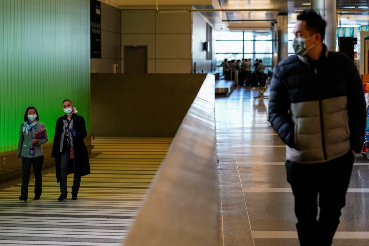 LOS ANGELES, CA - MARCH 18: People walk up the ramp, exiting the secure area at the Tom Bradley International Terminal at LAX on Wednesday, March 18, 2020 in Los Angeles, CA.
