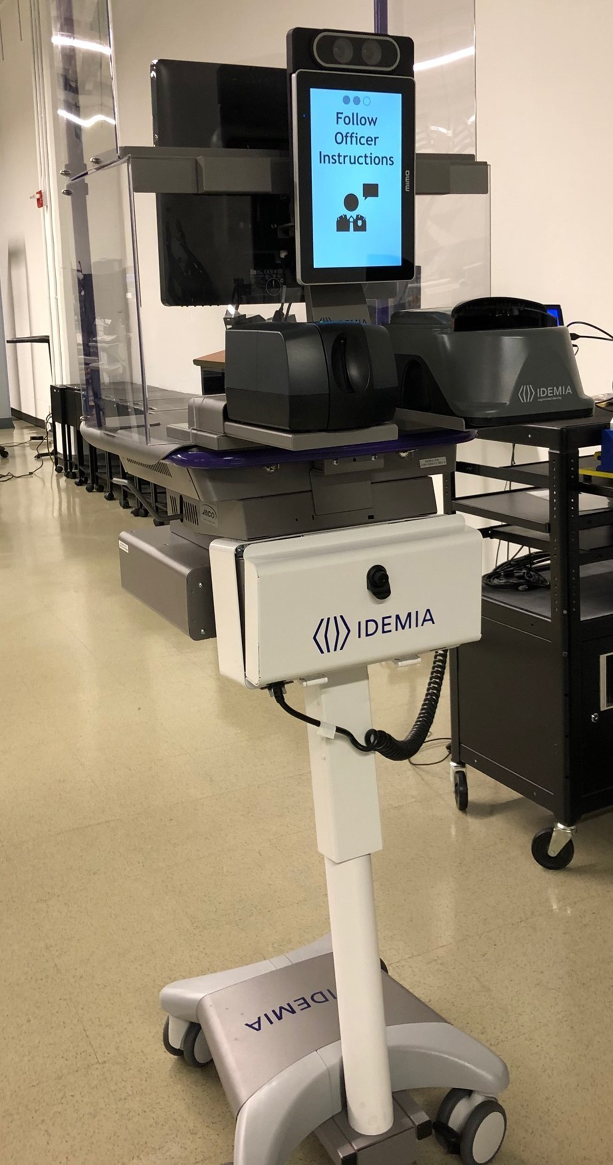 A look at the Idemia ID analysis machines in use for a pilot project at Ronald Reagan Airport. The officer stands behind the shield, and human-to-human contact is non-existent.