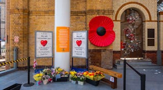 Manchester, UK - May 18 2018: Flowers are brought to a makeshift memorial at Manchester Victoria station on the one-year anniversary of the attack on Manchester Arena where 22 people lost their lives.