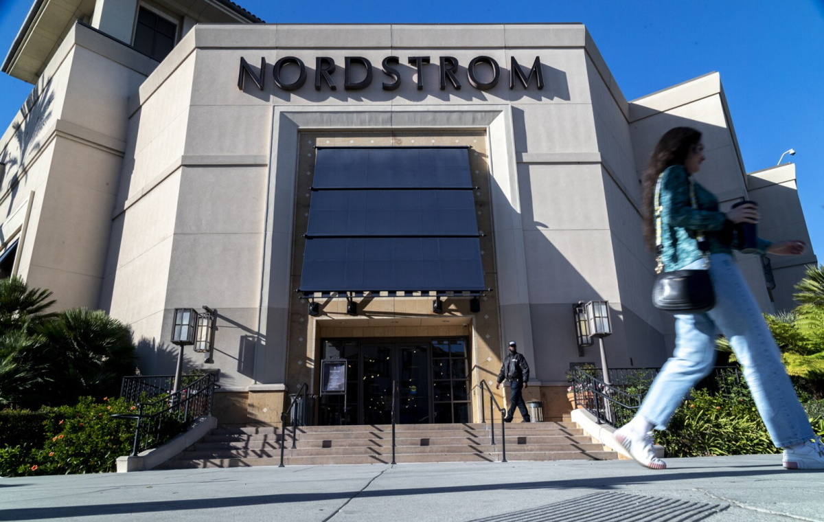 A security guard patrols the front entrance of a Los Angeles Nordstrom after an organized group of thieves attempted a smash-and-grab robbery last week.