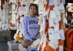 Stephanie Diaz, 16, a Highland Park High School junior, sits among messages left at the downtown memorial on Aug. 16, 2022, after the Fourth of July parade shooting.