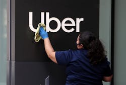 A worker cleans a sign in front of the Uber headquarters on May 18, 2020, in San Francisco, California. A worker cleans a sign in front of the Uber headquarters on May 18, 2020, in San Francisco, California.