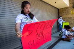 At a protest outside LAUSD headquarters in June, a student holds a sign she made with a friend as she and other students called for an end to police officers on campuses.