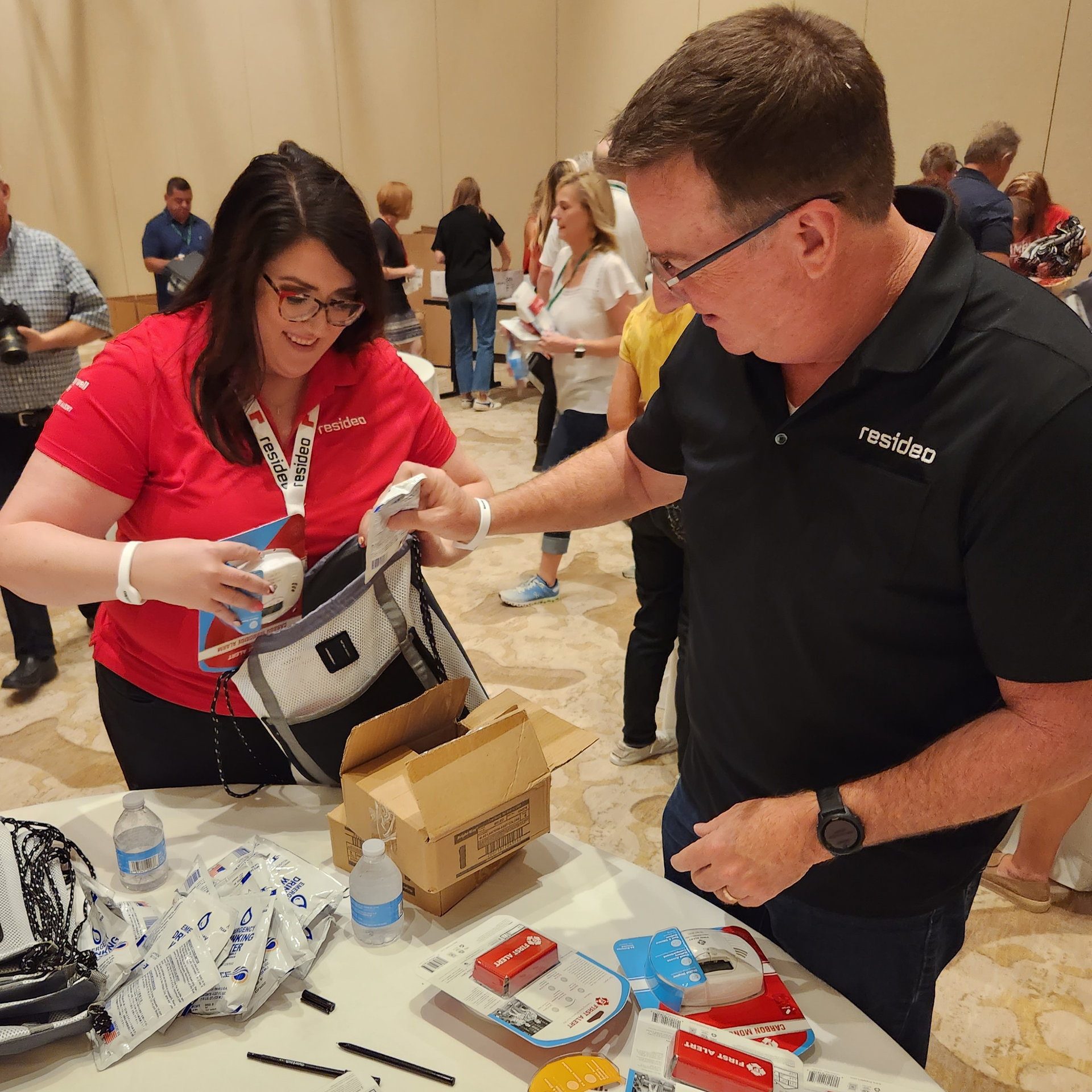 Resideo's Jamie Quanrud and Scott Harkins help pack a disaster relief kit for Florida residents.