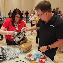 Resideo&apos;s Jamie Quanrud and Scott Harkins help pack a disaster relief kit for Florida residents.