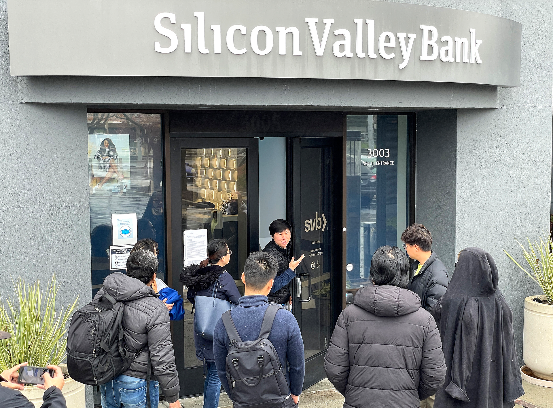 A worker, middle, tells customers that the Silicon Valley Bank headquarters is closed on Friday, March 10, 2023, in Santa Clara, California. Silicon Valley Bank was shut down on Friday morning by California regulators and was put in control of the U.S. Federal Deposit Insurance Corporation. (Justin Sullivan/Getty Images/TNS)