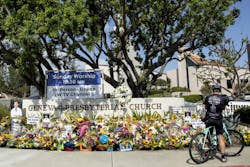 LAGUNA WOODS, CA - MAY 22: Warren Bidmead of Laguna Beach stops at the sidewalk memorial in front of the Geneva Presbyterian Church in Laguna Woods on Sunday, May 22, 2022. He said he rode past this location an hour before the shooting at the Irvine Taiwanese Presbyterian Church a week earlier. He said he couldn't imagine the horror of being together in church and this happening. LAGUNA WOODS, CA - MAY 22: Warren Bidmead of Laguna Beach stops at the sidewalk memorial in front of the Geneva Presbyterian Church in Laguna Woods on Sunday, May 22, 2022. He said he rode past this location an hour before the shooting at the Irvine Taiwanese Presbyterian Church a week earlier. He said he couldn't imagine the horror of being together in church and this happening.