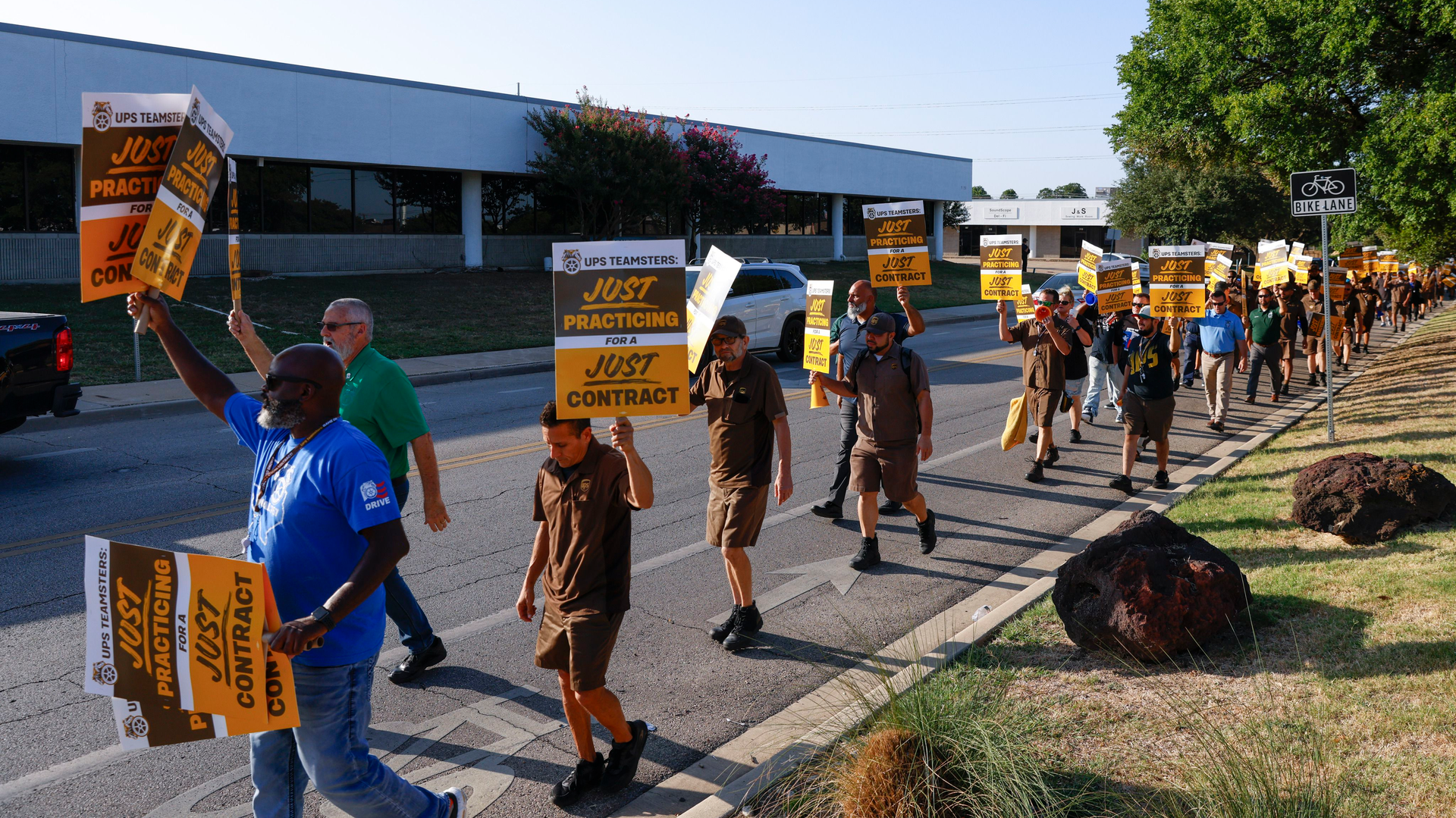 UPS employees practice pickets along Monroe Drive in Dallas on July 12, 2023. UPS employees are preparing to go on strike and have begun staging practice pickets across Texas for a union contract.