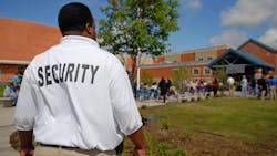 A security guards stands outside a public junior high school. A security guards stands outside a public junior high school.