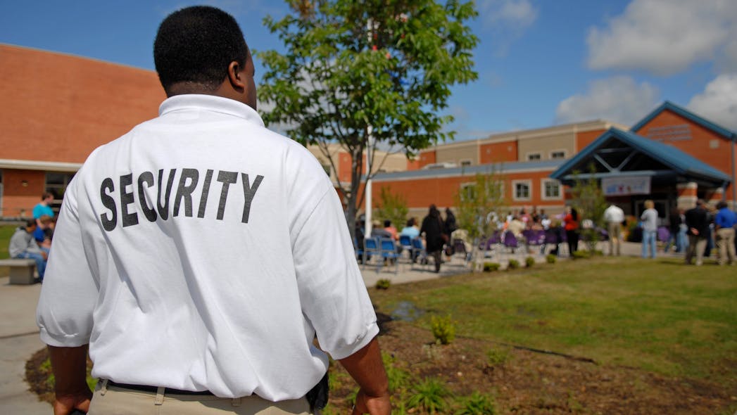 A security guards stands outside a public junior high school.
