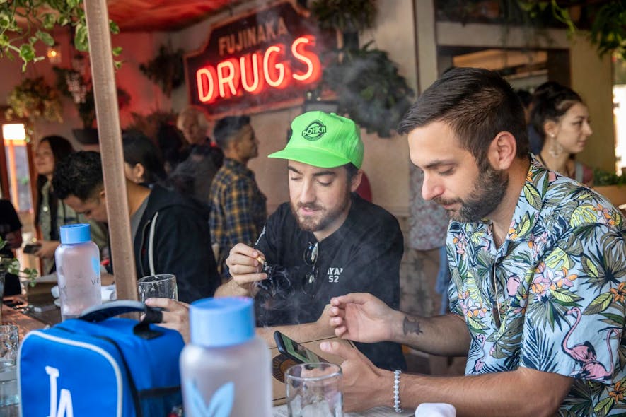 Patrons Connor Cacciottolo, left, and friend Tim Hitpas, right, enjoy a joint at Lowell Cafe, a new restaurant and cannabis bar in West Hollywood that allows diners to smoke marijuana inside and out thanks to a new license issued by the city in West Hollywood, Calif., on Oct. 1, 2019.