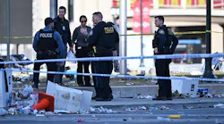 Police officers investigate the scene of a shooting where at least one person was killed and more than 20 others were injured after the Kansas City Chiefs Super Bowl LVIII victory parade Wednesday, Feb. 14, 2024, in Kansas City.