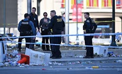 Police officers investigate the scene of a shooting where at least one person was killed and more than 20 others were injured after the Kansas City Chiefs Super Bowl LVIII victory parade Wednesday, Feb. 14, 2024, in Kansas City.