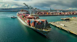 A tug boat maneuvers a cargo ship at dockside in Port of Long Beach, Calif..