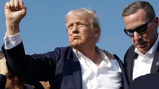 Republican presidential candidate former President Donald Trump pumps his fist as he is rushed offstage by Secret Service agents after being grazed by a bullet during a campaign rally on Saturday in Butler, Pa.