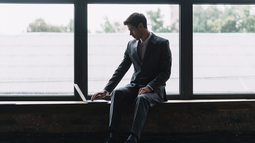 674f44082a90fe110864318e Youngbusinessmansittingfrontwindowtypinglaptop 232