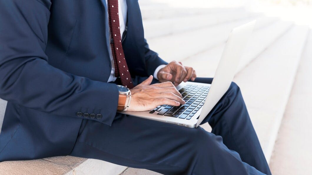 67892b129170561c5d23fa5f Closeupmansuitworkinglaptop 232148230795
