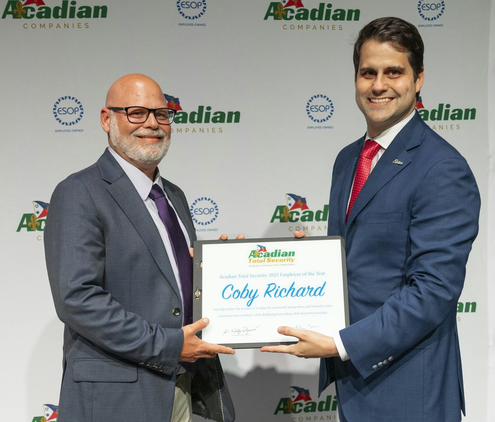 Acadian Companies Vice President Brandon Niles (R) presents Coby Richard (L) with the Acadian Total Security&rsquo;s 2025 Employee of the Year Award