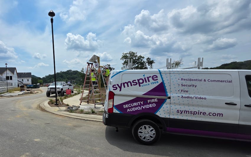 A Symspire technician team installs equipment at a new residential development site as the company&rsquo;s service vehicle stands nearby. Symspire provides integrated security, fire, and audio/video systems for residential and commercial customers across Tennessee.