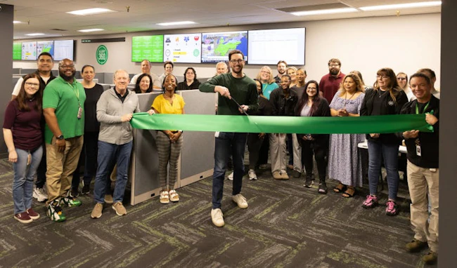 Executives and employees from Alert 360 participate in a ribbon-cutting ceremony for the company&rsquo;s new alarm and video monitoring center at its Tulsa headquarters.