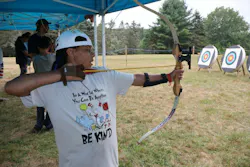 A young participant takes part in an archery activity at Children’s Burn Camp, which will receive support from funds raised during the Fire & Security Executive Club’s annual dinner Nov. 2 in New York City.